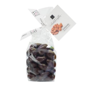 Photo d'un sachet de noix enrobés de chocolat, présenté sur un fond blanc.